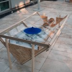 R.Rychter, AGREGAT obiekt, 2006 r. wymiary: 200x100x70 cm materiał: drewno, plexi, biała farba, niebieska farba w proszku, rura miedziana.