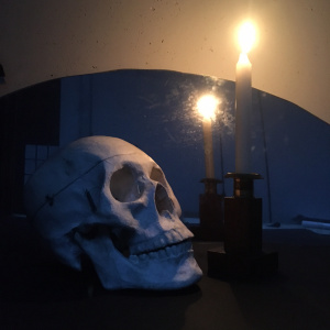zdjęcie przedstawia czaszkę i świecę