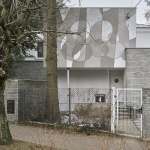 Sgraffito abstrakcyjne na fasadzie budynku, utrzymane w tonacji szarości i bieli.
