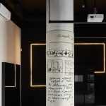 Sgraffito czarno-białe na szerokim słupie. Czarne ryte linie przedstawiają kolaż ze szkiców Andrzeja Wajdy