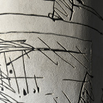 Fragment sgraffita na słupie. Szkicowe czarne linie, ryte są w białej zaprawie, przedstawiają karuzelę z filmu "Wszystko na sprzedaż" Andrzeja Wajdy.